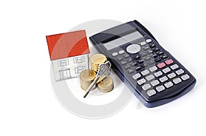 Mortgage loans concept with key and coins stack, paper house and calculator
