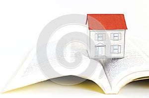 Mortgage loans concept with paper house on textbooks