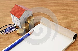 Mortgage loans concept with pencil and notepad with paper house