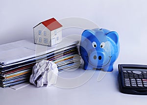 Mortgage loans concept with piggy bank and paper house on bill p