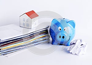 Mortgage loans concept with piggy bank and paper house on bill payment stacks