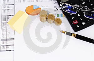 Mortgage loans concept with yellow paper funtain pen and coins and calculator and eyeglasses