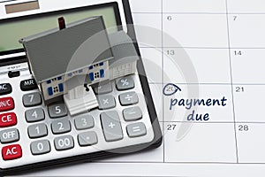 Mortgage payment due with house and calculator on a calendar