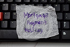 Mortgage Payment Holiday write on crunched paper isolated on wooden table photo