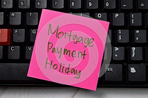 Mortgage Payment Holiday write on sticky note isolated on wooden table