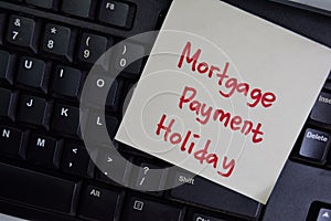 Mortgage Payment Holiday write on sticky notes isolated on Wooden Table