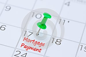 Mortgage Payment written on a calendar with a green push pin to