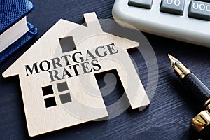 Mortgage rates written on a wooden model of house photo