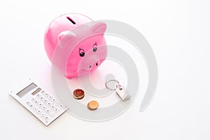 Mortgage. Savings for buy house. Moneybox in shape of pig near keychain in shape of car, coins, calculator on white