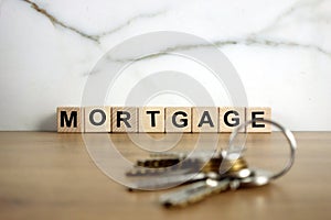 Mortgage word from wooden blocks and house keys. Real estate, renting property or moving home concept