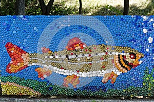 Mosaic with a river trout or salmo trutta fario  figure made of waste plastic caps