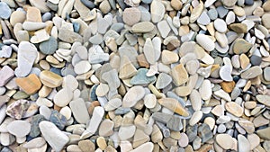 Mosaic sea pebbles background. Texture of small marine multi-colored pebbles. Marine design template for invitations,