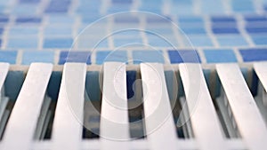 Mosaic side and white grille in blue and white, pool with clear transparent water