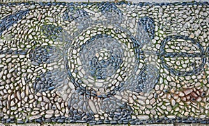 Mosaic of small stones on the floor.