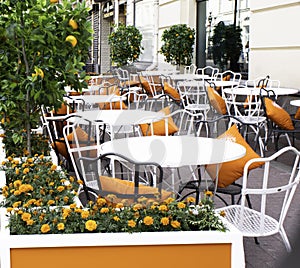 Moscow. August 2020g. outdoor cafe-Verandah in orange-green and white colors. Round tables, soft orange cushions on