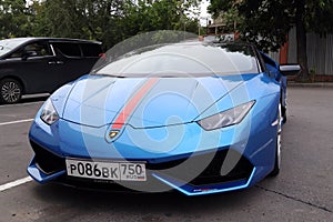 Moscow. Autumn 2018. Bright blue Lamborghini Huracan parked on the street. With red stripe on a car hood. Headlights and front