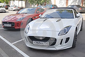 Moscow. Autumn 2018. Red and White cars. Two Jaguar F - type S parked near Porsche dealership