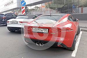 Moscow. Autumn 2018. Red and White cars. Two Jaguar F - type S parked near Porsche dealership