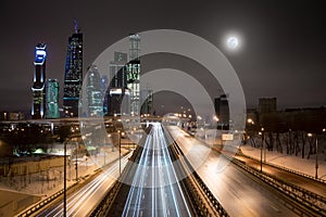 Moscow City skyscrapers and highway at full moon night