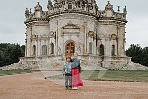 Moscow, Dubrovitsy 06.29.2021 two happy little kids siblings traveler on background of exterior of Orthodox building church temple