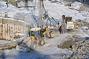 MOSCOW, FEB. 01, 2018: Winter view on dirty heavy construction equipment, vehicles workers at work. Drilling operations on constru