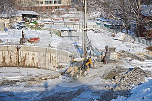 MOSCOW, FEB. 01, 2018: Winter view on dirty heavy construction equipment, vehicles workers at work. Drilling operations on constru