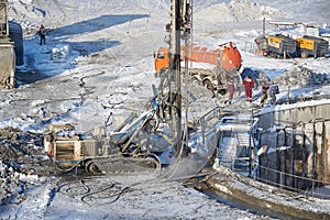 MOSCOW, FEB. 01, 2018: Winter view on dirty heavy construction equipment, vehicles and workers at work. Drilling operations on con