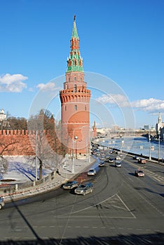 Moscow Kremlin tower and wall. Cars drive along the Moscow river embankment.