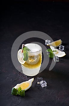 Moscow Mule Cocktail on a dark background. Cold drink, Layered white and yellow with vodka, spicy ginger beer, and lime