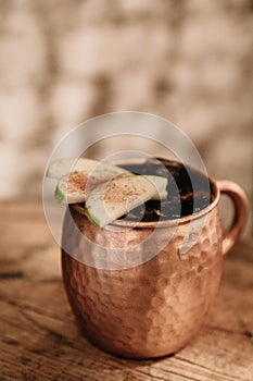 Moscow Mule cocktail garnished with apples and cinnamon