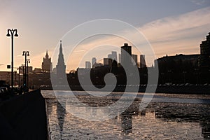 Moscow river, embankment and silhouettes of buildings and towers on sunset