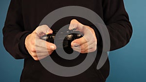 Moscow Russia 20 september 2019 a man in a black hoodie holds an xbox controller on a blue background
