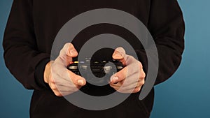 Moscow Russia 20 september 2019 a man in a black hoodie holds an xbox controller on a blue background.