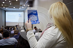 Young blond woman stands with booklet in hand in photo