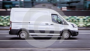 Ford Transit Fourth generation in the city street. Side view of white light commercial vehicle