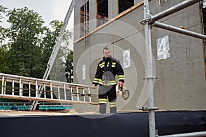 Firefighter stand next to dummy building photo