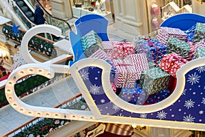 Moscow, Russia - December 15, 2020: Huge sleigh with christmas gifts holdung under ceiling at GUM department store. Festive