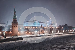 Moscow, Russia - December 27, 2022: Tower of the Moscow Kremlin. Cold and deserted Moscow street on a snowy winter evening near