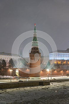 Moscow, Russia - December 27, 2022: Tower of the Moscow Kremlin. Cold and deserted Moscow street on a snowy winter evening near