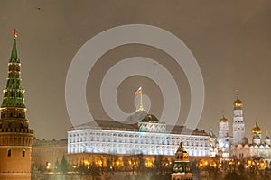 Moscow, Russia - December 27, 2022: Tower of the Moscow Kremlin. Cold and deserted Moscow street on a snowy winter evening near