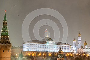 Moscow, Russia - December 27, 2022: Tower of the Moscow Kremlin. Cold and deserted Moscow street on a snowy winter evening near