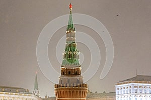 Moscow, Russia - December 27, 2022: Tower of the Moscow Kremlin. Cold and deserted Moscow street on a snowy winter evening near