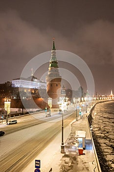 Moscow, Russia - December 27, 2022: Tower of the Moscow Kremlin. Cold and deserted Moscow street on a snowy winter evening near