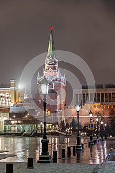 Moscow, Russia - December 27, 2022: Tower of the Moscow Kremlin. Cold and deserted Moscow street on a snowy winter evening near