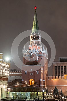 Moscow, Russia - December 27, 2022: Tower of the Moscow Kremlin. Cold and deserted Moscow street on a snowy winter evening near