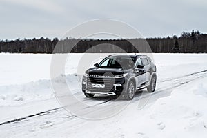 MOSCOW, RUSSIA - FEBRUARY 23, 2021 CHERYEXEED TXL SUV car in motion front side view. Black SUV on nature background