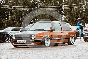 Moscow, Russia - July 06, 2019: Volkswagen Golf 2 yellow-brown in the parking lotin the rain . classic car with lowered suspension