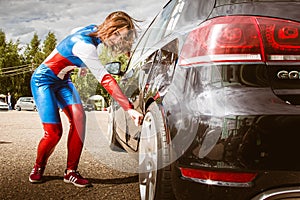 Moscow, Russia - July 06, 2020: Woman Captain America. He hits the car and a dent remains on it. Girl superhero. Costume. wonder