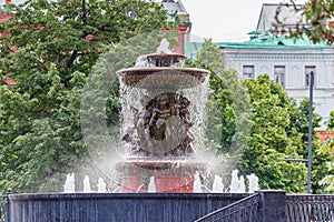 Moscow, Russia - June 02, 2019: Fountain Vitali on Revolution Square in Moscow against green trees closeup