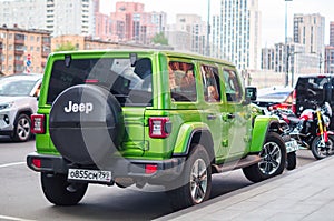 Green Jeep Wrangler Unlimited 4x4 SUV car parked on the street in the city